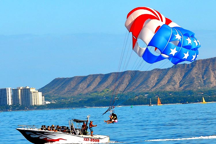 Oahu parasailing tour boat pulling a rider with Diamond Head Crater in the background