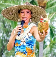 Woman holding a signature cocktail in a pineapple at Diamond Head Luau
