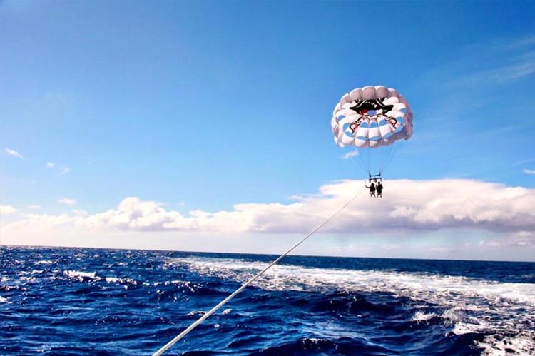 Two people parasailing above Waikiki Bay on Tour Hawaii's Oahu Parasailing Tour