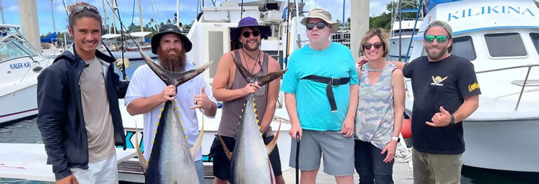 Guests hold up large Yellowfin Tuna on the dock the Deep Sea Fishing Oahu.